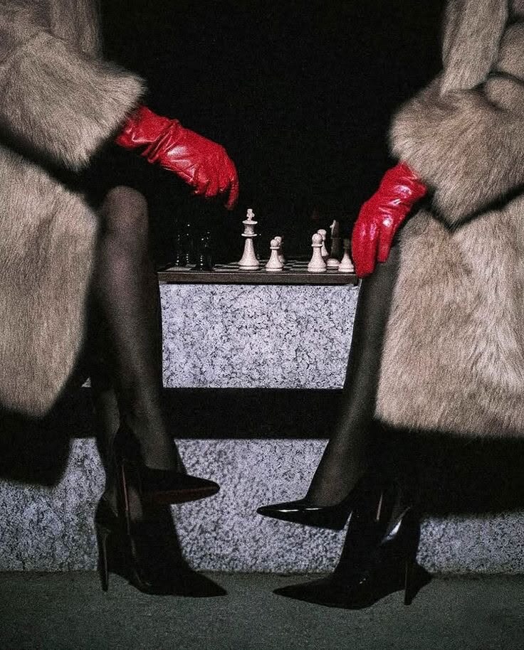 Two poised figures in red gloves facing a chessboard, evoking strategy and inner command