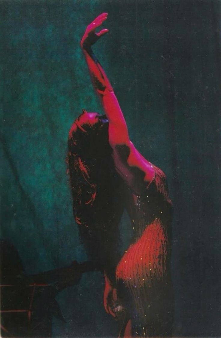 A poised figure reaching upward in red light against a deep teal background, symbolizing self-command
