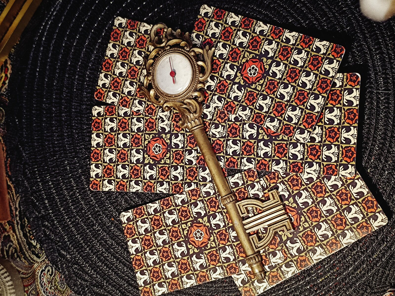 An ornate brass key laid across patterned Tarot card backs
