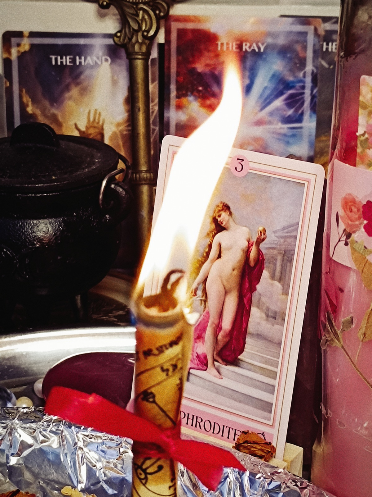 The Venus in Bloom petition candle burning before an Aphrodite card at the Galerie Rberry altar